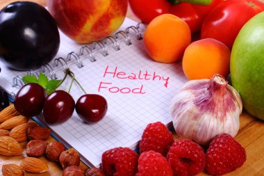 Fruits and vegetables with notebook, slimming and healthy food