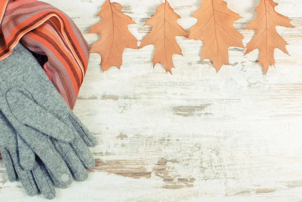 Vintage photo, Womanly woolen clothes and autumnal leaves with copy space for text, old rustic wooden background — Stock Photo, Image