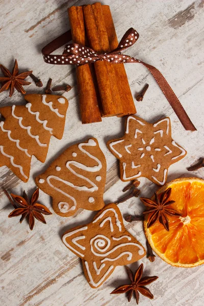 Nybakat dekorerade pepparkakor med kryddor på gamla trä bakgrund, juletid — Stockfoto