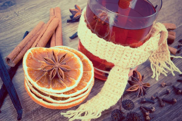 Vintage photo, Glass of mulled wine wrapped scarf with fresh fragrant spices — Stock Photo, Image