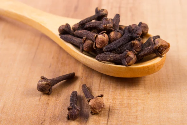 Nelkenhaufen mit Holzlöffel auf dem Tisch, Würze zum Kochen — Stockfoto