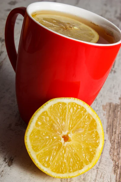 Citron frais et tasse de thé chaud sur une table en bois, une alimentation saine — Photo