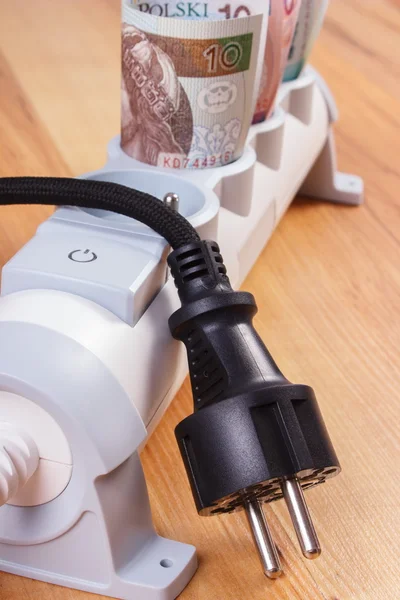 Rullar med polsk valuta pengar i elektriska grenuttag och frånkopplad plug, energikostnader — Stockfoto