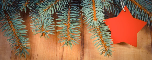 Foto vintage, ramas de abeto y estrella de madera roja con espacio de copia para el texto — Foto de Stock