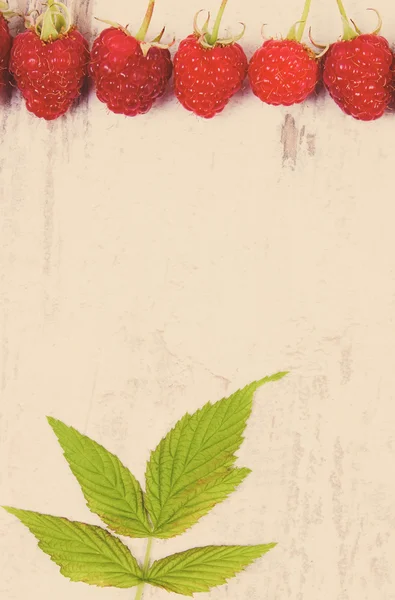 Vintage photo, Fresh raspberries with leaf and copy space for text on old wooden background — 图库照片