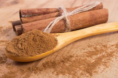 Powdery cinnamon and sticks on wooden table, seasoning for cooking