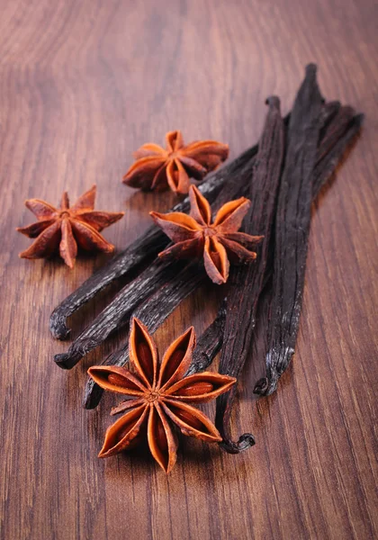 Fragrant vanilla and star anise on wooden surface plank — 图库照片