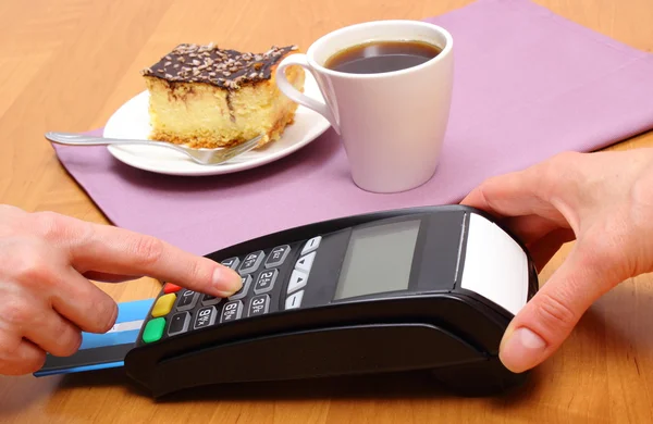 用付款终端支付的起司蛋糕和咖啡在咖啡厅，金融概念 — 图库照片
