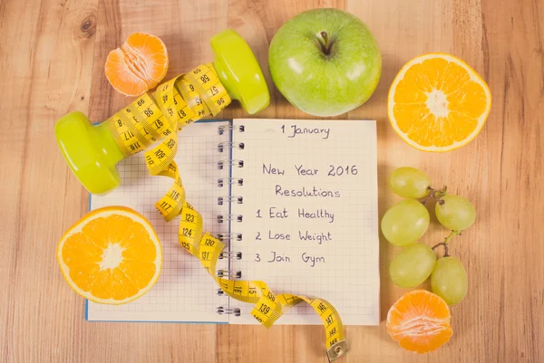 Vintage photo, New years resolutions written in notebook and dumbbells with centimeter — Stockfoto