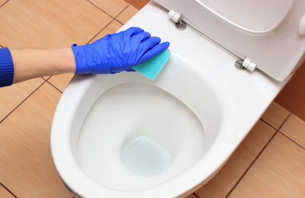 Hand of woman in blue glove cleaning toilet bowl — Stock Photo, Image