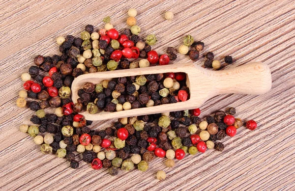 Verse gekleurde peper met lepel op houten achtergrond — Stockfoto