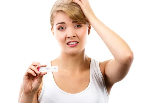Несчастная и обеспокоенная женщина показывает тест на беременность с положительным результатом Стоковое Изображение