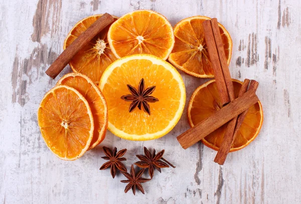 Gedroogde en verse oranje met specerijen op oude houten achtergrond — Stockfoto