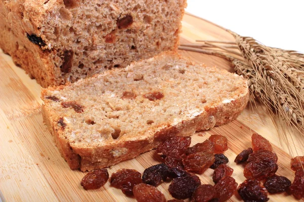 Fresh baked bread, ears of wheat and raisins — Stock Photo, Image