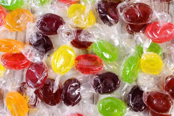 Montón de caramelos de colores como fondo, demasiados dulces — Foto de Stock