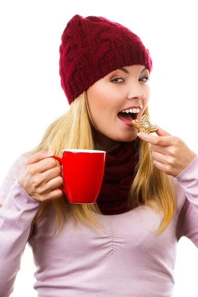 Donna sorridente in berretto di lana e scialle con biscotti di pan di zenzero e tè, sfondo bianco, periodo natalizio — Foto Stock