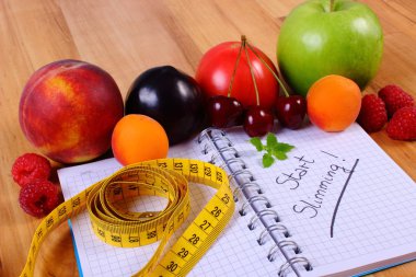 Meyve, sebze ve santimetre ile defter, zayıflama ve sağlıklı gıda