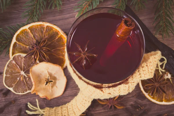 Vintage photo, Glass of mulled wine wrapped scarf, spices and spruce branches — Stock Photo, Image