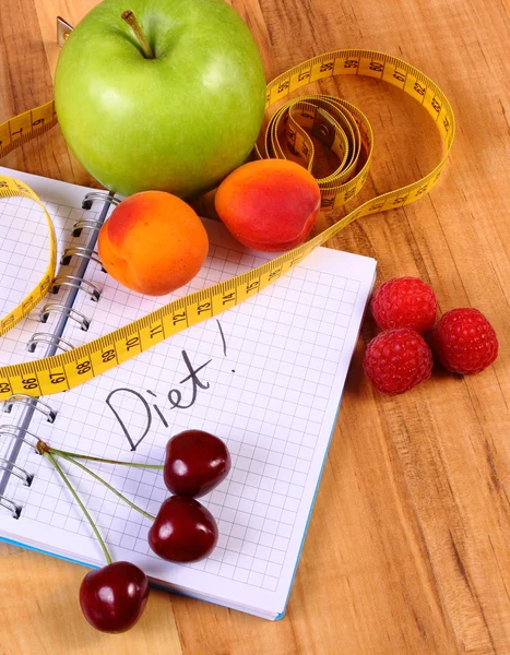 Fruits and centimeter with notebook, slimming and healthy food — Stock Photo, Image