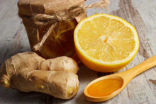 Свежий лимон, мед и имбирь на деревянном столе, здоровое питание — стоковое фото