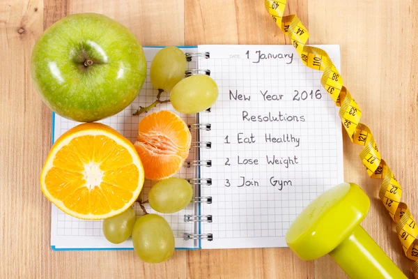 Resoluciones de año nuevo escritas en cuaderno y frutas, mancuernas con centímetro — Foto de Stock