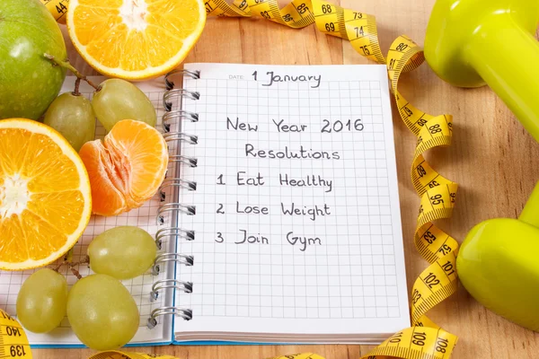 Résolutions du Nouvel An écrites dans un cahier et des fruits, haltères avec centimètre — Photo
