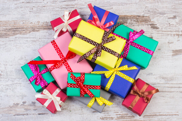 Завернутые красочные подарки на Рождество или другой праздник на старой белой доске
