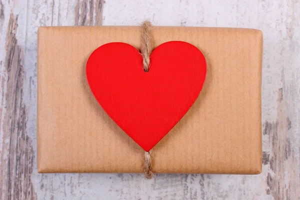 Coeurs rouges avec cadeau enveloppé pour la Saint Valentin sur une vieille table en bois — Photo