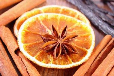 Yıldız anason, kokulu vanilya, tarçın ve ahşap yüzey üzerinde kurutulmuş portakal