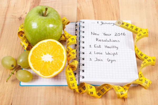 New years resolutions written in notebook and tape measure — Stock Photo, Image