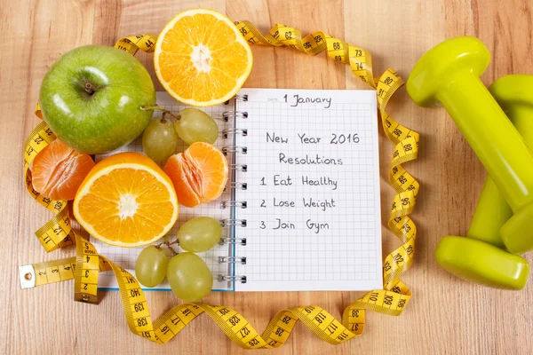 New years resolutions written in notebook and fruits, dumbbells with centimeter — Stock Photo, Image