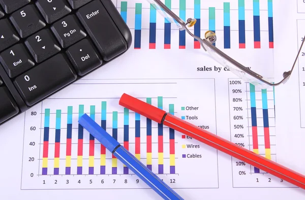 Pen, glazen en computer toetsenbord op financiële grafiek, bedrijfsconcept — Stockfoto