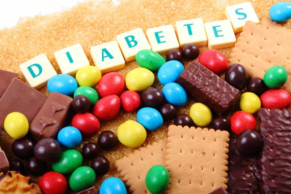 Um monte de doces, açúcar mascavo e diabetes palavra, comida não saudável — Fotografia de Stock