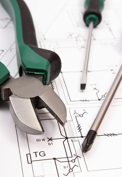 Metal pliers and screwdriver on electrical construction drawing of house — Stockfoto