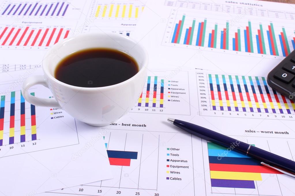 Pen, calculator and cup of coffee on financial graph, business concept