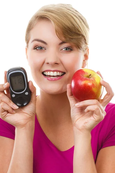 Mulher feliz segurando glicosímetro e maçã fresca, medindo e verificando o nível de açúcar, conceito de diabetes — Fotografia de Stock