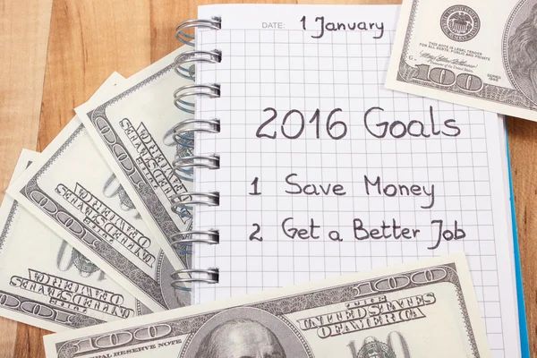 Ano Novo resoluções escritas em notebook e moedas dólar — Fotografia de Stock