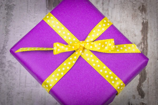 Фіолетовий подарунок на Різдво або інше святкування на дерев'яній дошці — стокове фото