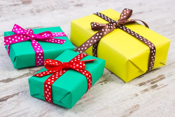 Verpakt kleurrijke cadeaus voor Kerstmis of andere viering op oude witte plank — Stockfoto