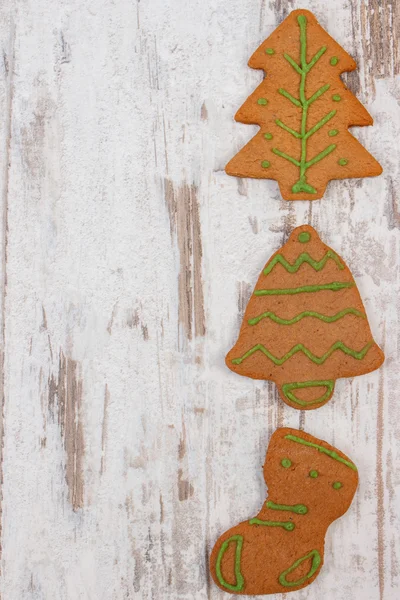 Pane di zenzero fresco decorato al forno su vecchio sfondo di legno, periodo natalizio — Foto Stock