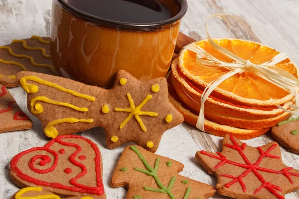 Fresh gingerbread, cup of coffee and dried orange on old wooden background, christmas time — Stock Photo, Image