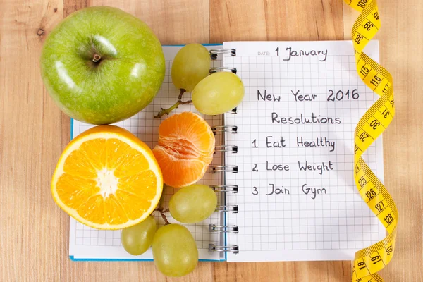 Resoluciones de año nuevo escritas en cuaderno y cinta métrica — Foto de Stock