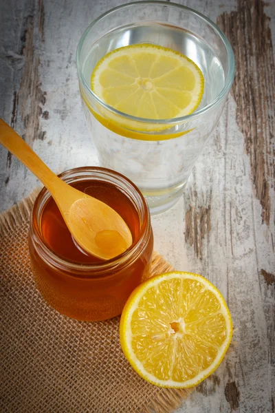 Taze limon bal ve su bir bardak dilim limon ile — Stok fotoğraf