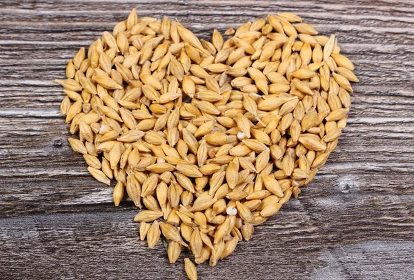 Heart of barley grain on wooden background — Stock Photo, Image