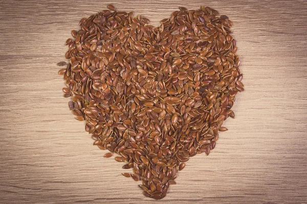 Foto vintage, Corazón de linaza sobre fondo de madera — Foto de Stock