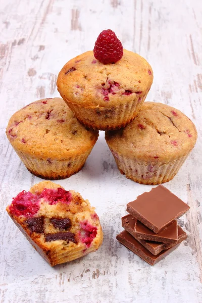 Vers gebakken muffins met frambozen en chocolade op houten achtergrond, heerlijk dessert — Stockfoto