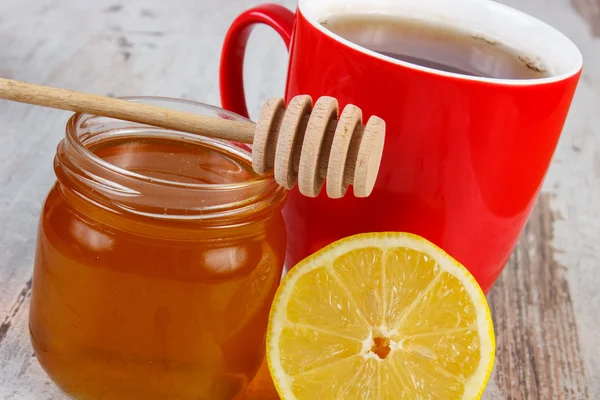 Fresh lemon with honey and cup of tea on wooden table, healthy nutrition — Stock Photo, Image