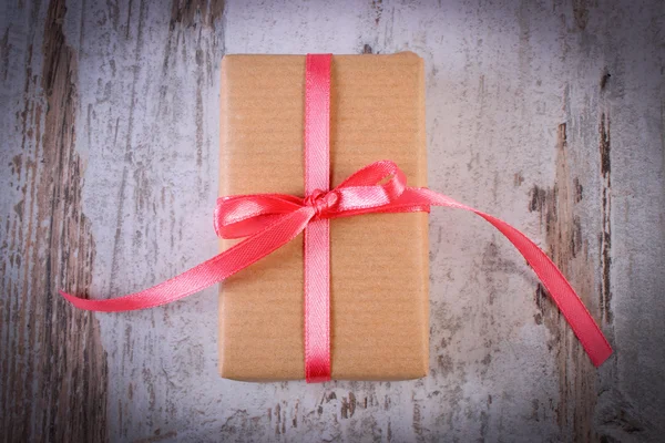 Wrapped gift for Valentines day on old wooden table — Stockfoto
