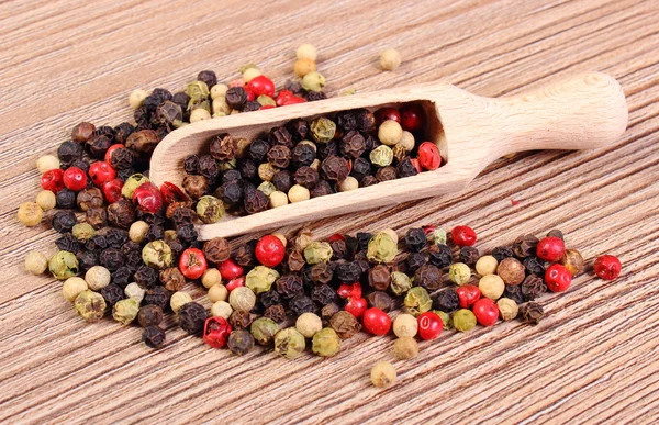 Verse gekleurde peper met lepel op houten achtergrond — Stockfoto