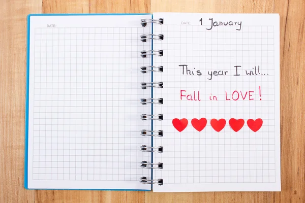 New years resolutions written in notebook and red paper hearts — Stock Photo, Image